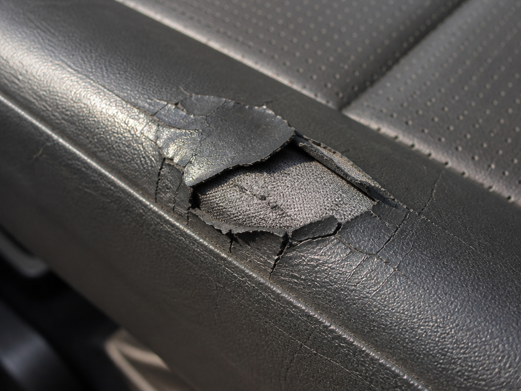 Close-up of cracked and peeling PU leather showing common failure modes.