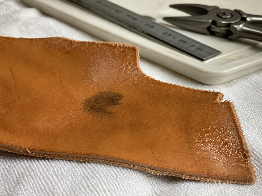Damp leather with permanent metal stain, isolated on a towel away from tools.